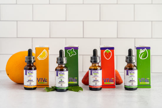 A serene wellness space featuring CBD products like a honey stick, roll-on, pet tinctures and treats, colorful gummies, a bath bomb, a vape pen, and a tincture bottle arranged among lush green hemp plants.